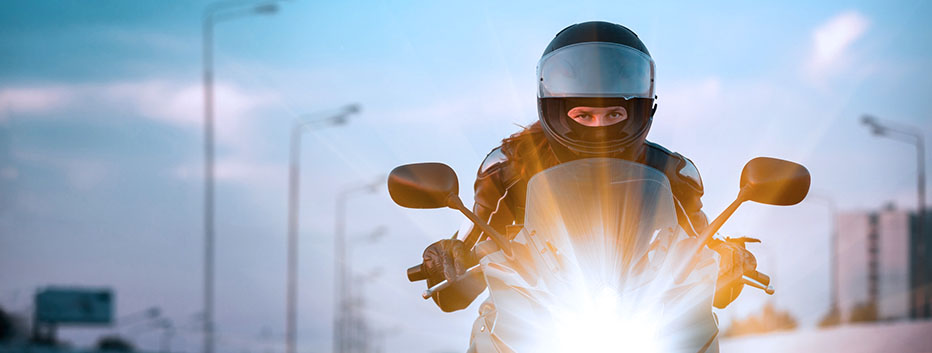 Man wearing helmet riding motorcycle at night