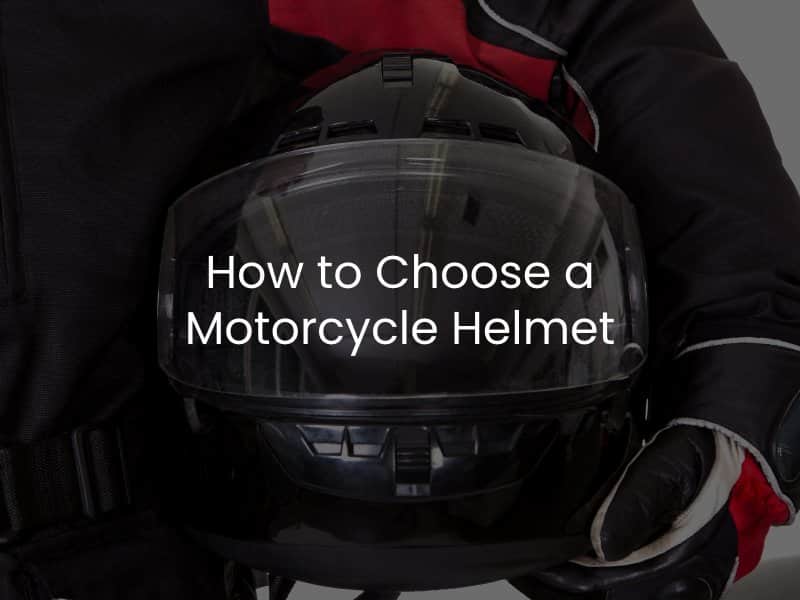 Motorcyclist holding motorcycle helmet